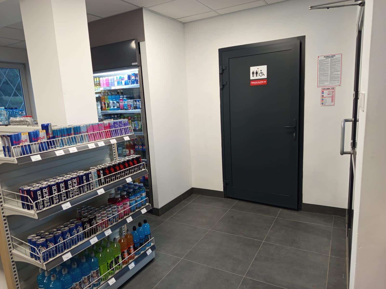 Wnętrze sklepu na stacji paliw Romgaz w Tuchomiu — napoje, przekąski i wejście do toalety